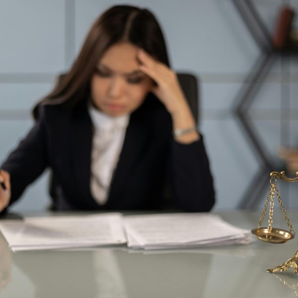 lawyer at a desk with documents and a Scale of Justice
