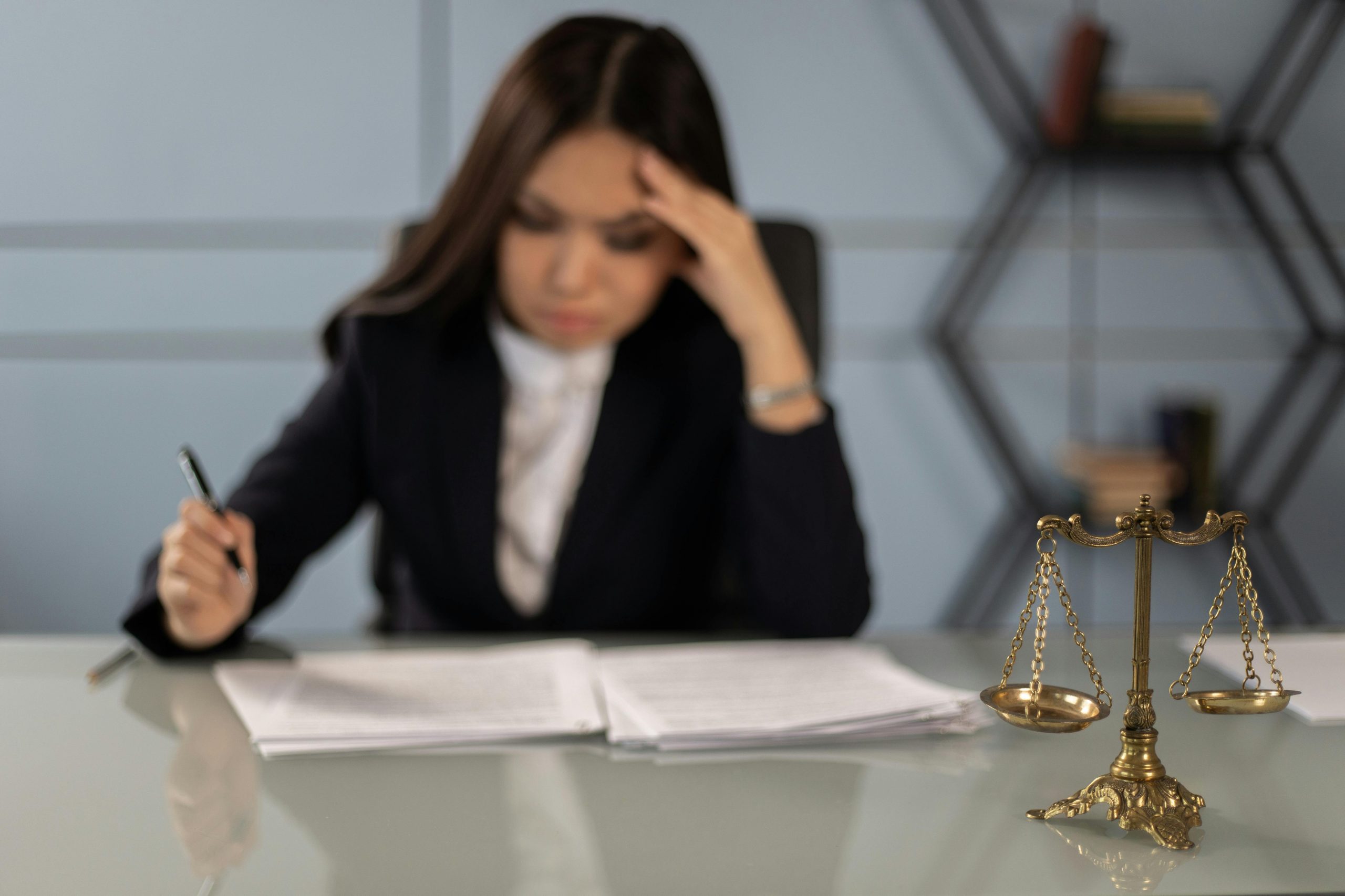 lawyer at a desk with documents and a Scale of Justice